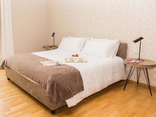 Charming bedroom with a neutral color scheme, comfortable bedding, and a contemporary side table 